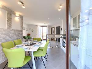 une salle à manger et une cuisine avec une table et des chaises vertes dans l'établissement Apartment Joy by Interhome, à Pula