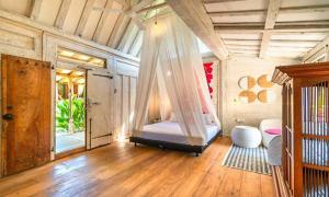 a bedroom with a bed with a mosquito net at Chanteak Bali in Jimbaran