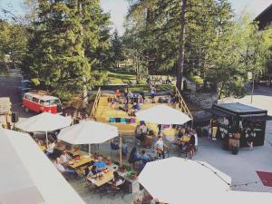 una vista in alto delle persone sedute ai tavoli con ombrelloni di Kurhaus Lenzerheide a Lenzerheide