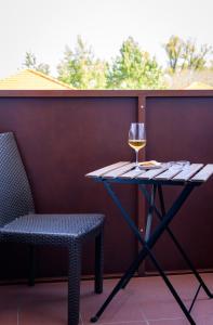 une table avec un verre de vin et une chaise dans l'établissement Hotel Römerhof, à Tulln