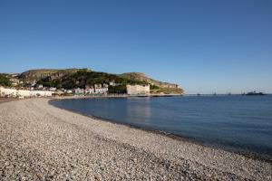 een strand met een rotsachtige kustlijn en de oceaan bij The County Hotel in Llandudno