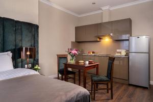 una camera con letto e una cucina con frigorifero di Greguar Hotel by UHM a Kiev