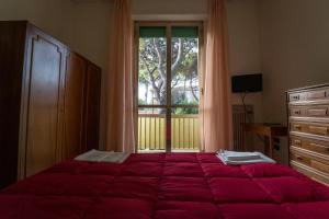 una camera da letto con un letto e una grande finestra di HOTEL CONCORDIA a Montecatini Terme