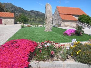 einen Garten mit Blumen vor einem Gebäude in der Unterkunft Quinta da Pedra Grande in Monsanto