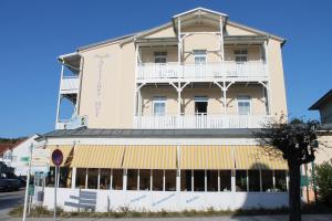 un grande edificio bianco con balcone in cima di Hotel Selliner Hof a Ostseebad Sellin