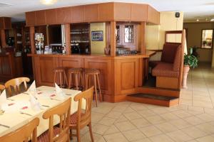 un ristorante con bar con tavoli e sedie bianchi di Hotel Selliner Hof a Ostseebad Sellin