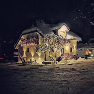 duży dom ze śniegiem na górze w obiekcie Hotel Rosengarten w mieście Tarvisio