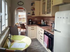 a kitchen with a white refrigerator and a table at Ferienhaus Püttbergeweg, Berlin in Berlin