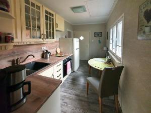 a kitchen with a white refrigerator and a table at Ferienhaus Püttbergeweg, Berlin in Berlin