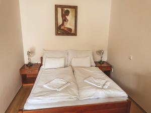 a bed with white sheets and pillows on it at Gizela in Luhačovice