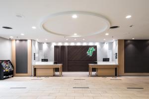 Holiday Inn Newark International Airport في نيوآرك: لوبي وطاولتين وشاشة كبيرة