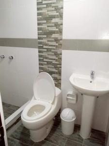 a bathroom with a toilet and a sink at Hostal Mirador Korichaska in Puno