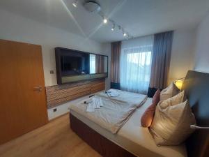 a hotel room with a bed with a television on the wall at Wohnambiente in Selb