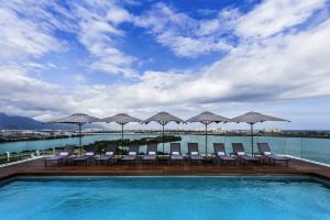 ein Pool mit Stühlen und Sonnenschirmen auf einem Gebäude in der Unterkunft Lagune Barra Hotel in Rio de Janeiro