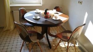 a table with four chairs and a coffee maker on it at Apartment am Südpark in Merseburg