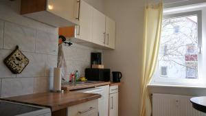 a kitchen with white cabinets and a sink and a window at Apartment am Südpark in Merseburg