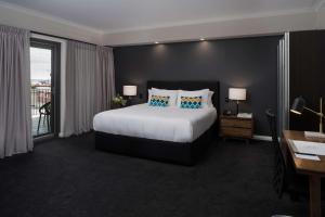 a hotel room with a bed and a desk and a window at Esplanade Hotel Fremantle - by Rydges in Fremantle