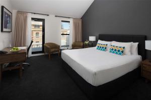 a hotel room with a bed and a desk and a desk at Esplanade Hotel Fremantle - by Rydges in Fremantle