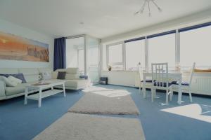 Ferienwohnung Schleiloge mit Panoramablick auf die Schlei في شلسفيغ: غرفة معيشة مع أريكة وطاولة