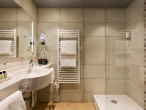 y baño con lavabo y ducha. en Hôtel Roi Soleil Prestige Plaisir - St Quentin, en Plaisir