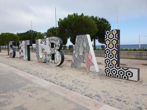 rząd znaków w piasku na plaży w obiekcie Setúbal Health Beach w mieście Setúbal