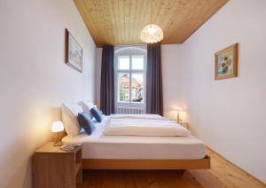 a bedroom with a large bed and a window at Goldengel Ferienwohnung im Herzen Kalterns mit einer Terasse zum verlieben in Caldaro