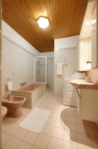 a bathroom with a tub and a toilet and a sink at Goldengel Ferienwohnung im Herzen Kalterns mit einer Terasse zum verlieben in Caldaro