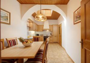 a kitchen with a wooden table with a bowl of fruit on it at Goldengel Ferienwohnung im Herzen Kalterns mit einer Terasse zum verlieben in Caldaro