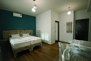 1 dormitorio con cama y pared azul en Hotel Kutaisi Globus, en Kutaisi