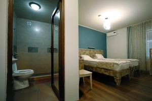 Habitación con baño con cama y aseo. en Hotel Kutaisi Globus, en Kutaisi