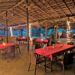 MolemNature's Nest Eco Resort Goa, Near Dudhsagar Waterfalls的一间餐厅,房间内设有红色的桌椅