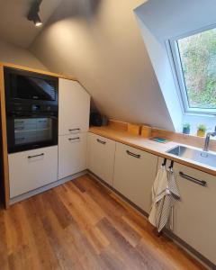 a kitchen with white cabinets and a sink and a window at Apartamenty Magiczna Wenecja in Cieszyn