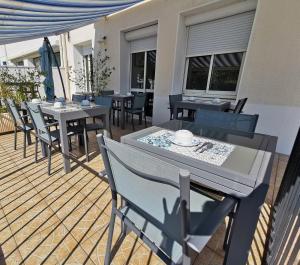 een terras met tafels en stoelen bij Hotel le Pasteur in Royan