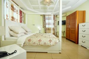 1 dormitorio blanco con 1 cama y vestidor en FELICIA HOTEL YAOUNDE, en Yaoundé