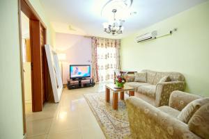 sala de estar con sofá y TV en FELICIA HOTEL YAOUNDE, en Yaoundé