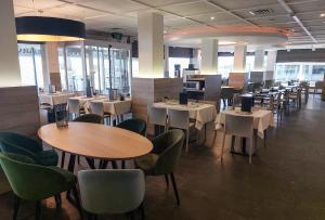 a dining room with tables and chairs and tablesktop at Hotel Sandeshoved Zeedijk in Nieuwpoort