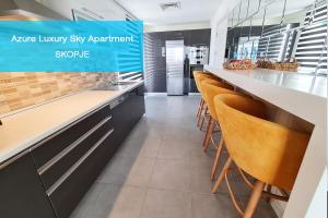 una cocina con sillas naranjas en un apartamento de lujo vacío en el cielo en Azure Luxury Sky Apartment, en Skopje