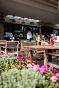 a wooden table with glasses of wine and flowers at Hotel Löwenhof in Bressanone