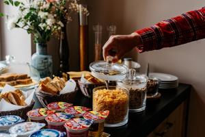 a person pouring food into a jar on a table at Pension Padre in Ostrava