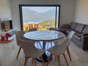 uma sala de estar com uma mesa e cadeiras e um sofá em Appartement neuf 3 chambres vue mer Propriano em Propriano