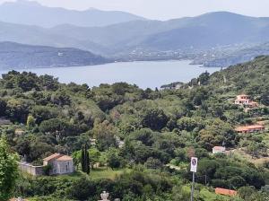 uma vista para um lago a partir de uma colina com árvores em Diaboliko Apartment em Capoliveri