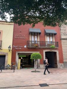 Ein Mann, der vor einem Gebäude läuft in der Unterkunft Hotel Madero in Querétaro