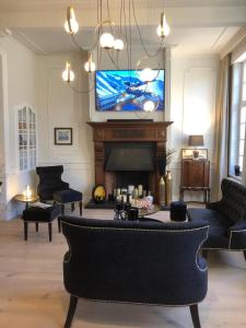 sala de estar con chimenea y TV en St-Georges IV, en Ypres