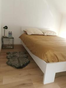 - une chambre avec un lit et une table avec une lampe dans l'établissement Le caillou Blanc, à Charleroi