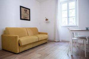 ein Wohnzimmer mit einem gelben Sofa und einem Tisch in der Unterkunft City Gallery Apartments in Triest