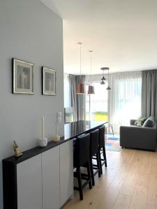 eine Küche und ein Wohnzimmer mit einem Tisch und Stühlen in der Unterkunft Made for You AMC apartament przy AquaParku in Rumia