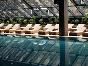 una piscina con sedie a sdraio e soffitto in vetro di Select Hill Resort a Tirana