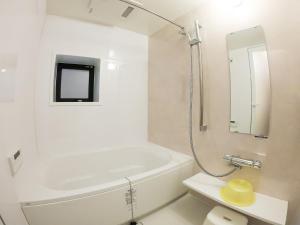 a white bathroom with a tub and a sink at Hotel S-Presso West - Vacation STAY 9085 in Osaka