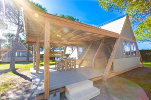 a large wooden house with a deck in a yard at Glamping Gli Etruschi in Piombino