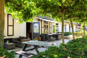 une terrasse avec des canapés et une table en face d'une maison dans l'établissement EuroParcs De Hooge Veluwe, à Arnhem